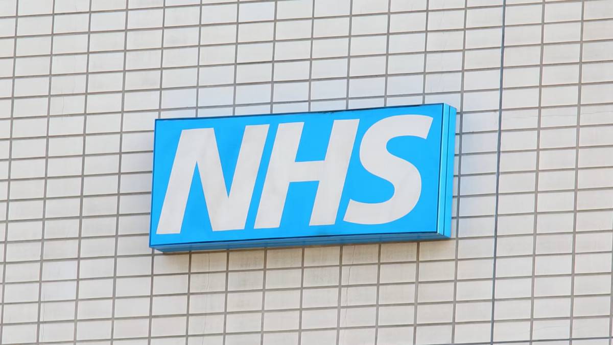 A blue NHS sign mounted on the exterior wall of a healthcare building.